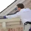 Rodent control technician sealing roofline entry points to prevent rodents in {city}, {state}